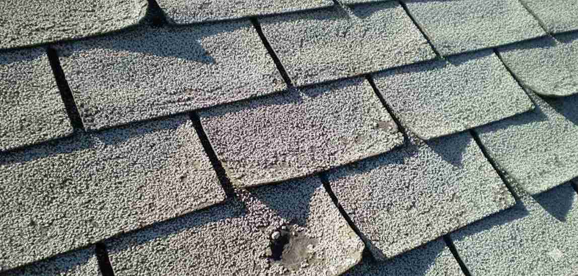 Sun and heat damaged shingles with fading and curling edges
